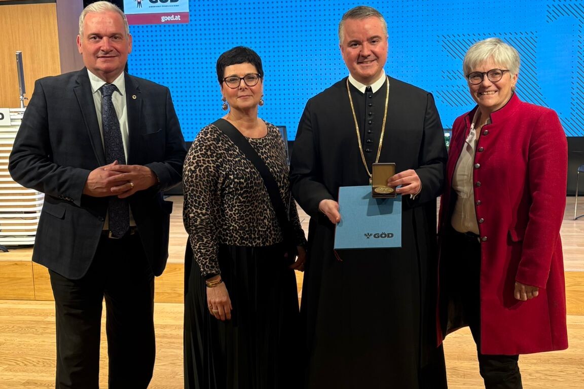 Direktorin mit zwei Lehrern und einer Lehrerin mit Auszeichnung Johannes-Messner Medaille, in die Kamera blickend.