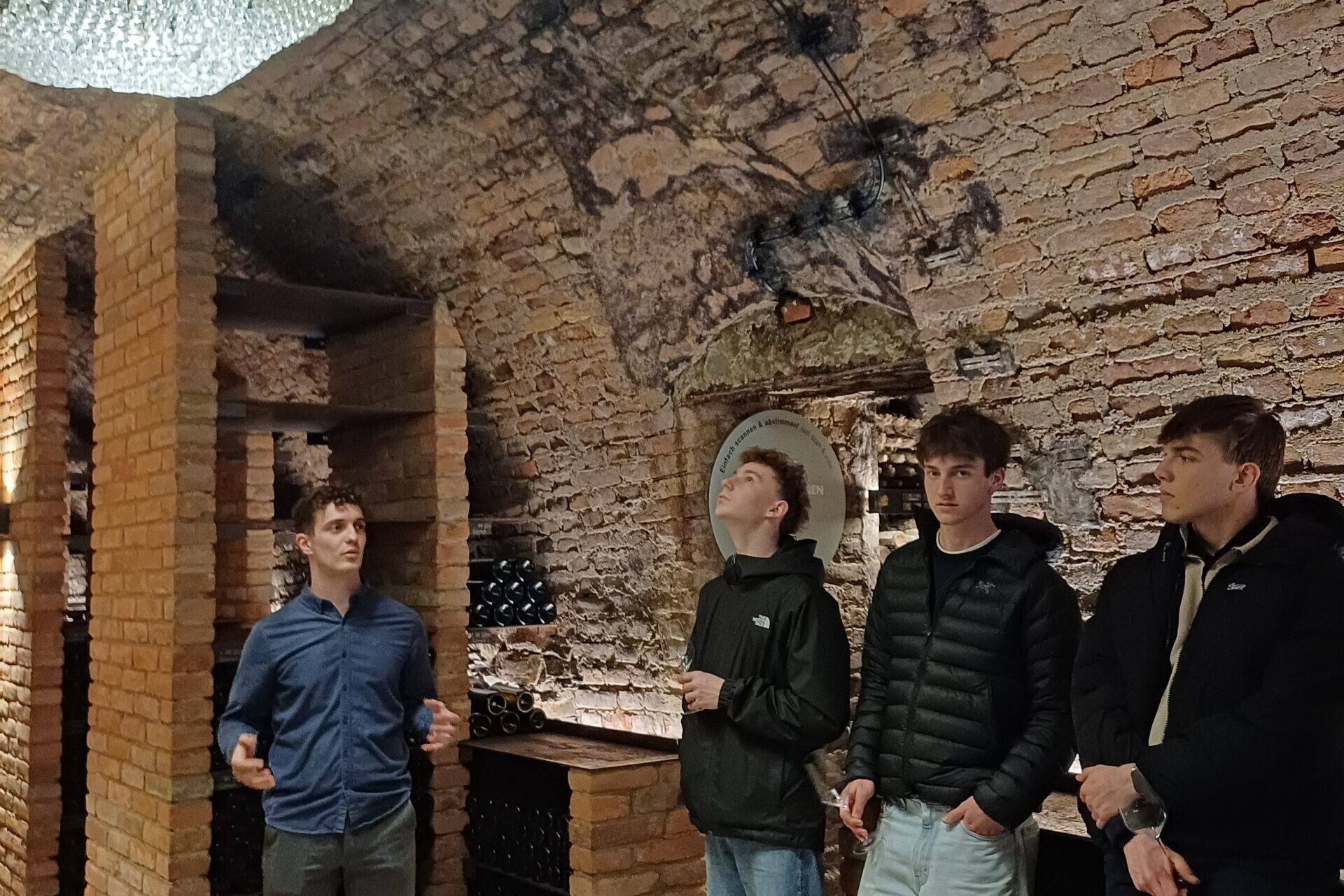 3 Schüler und ein Betreuer in einem Weinkeller.