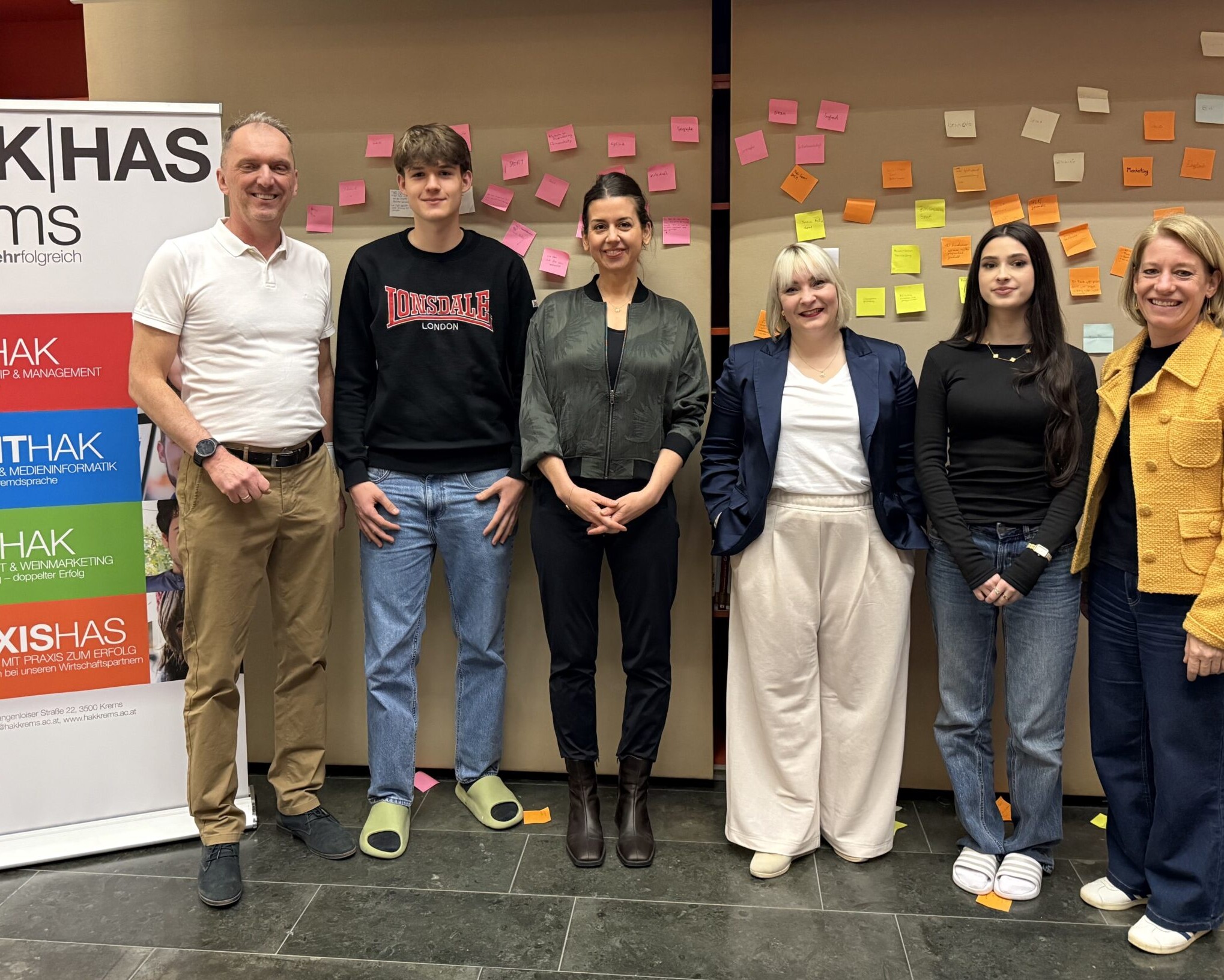 2 Lehrer:innen, 2 Schüler:innen und 2 Betreuerinnen des Entrepreneurship-Day stehen vor einer Wand mit Post-Its.
