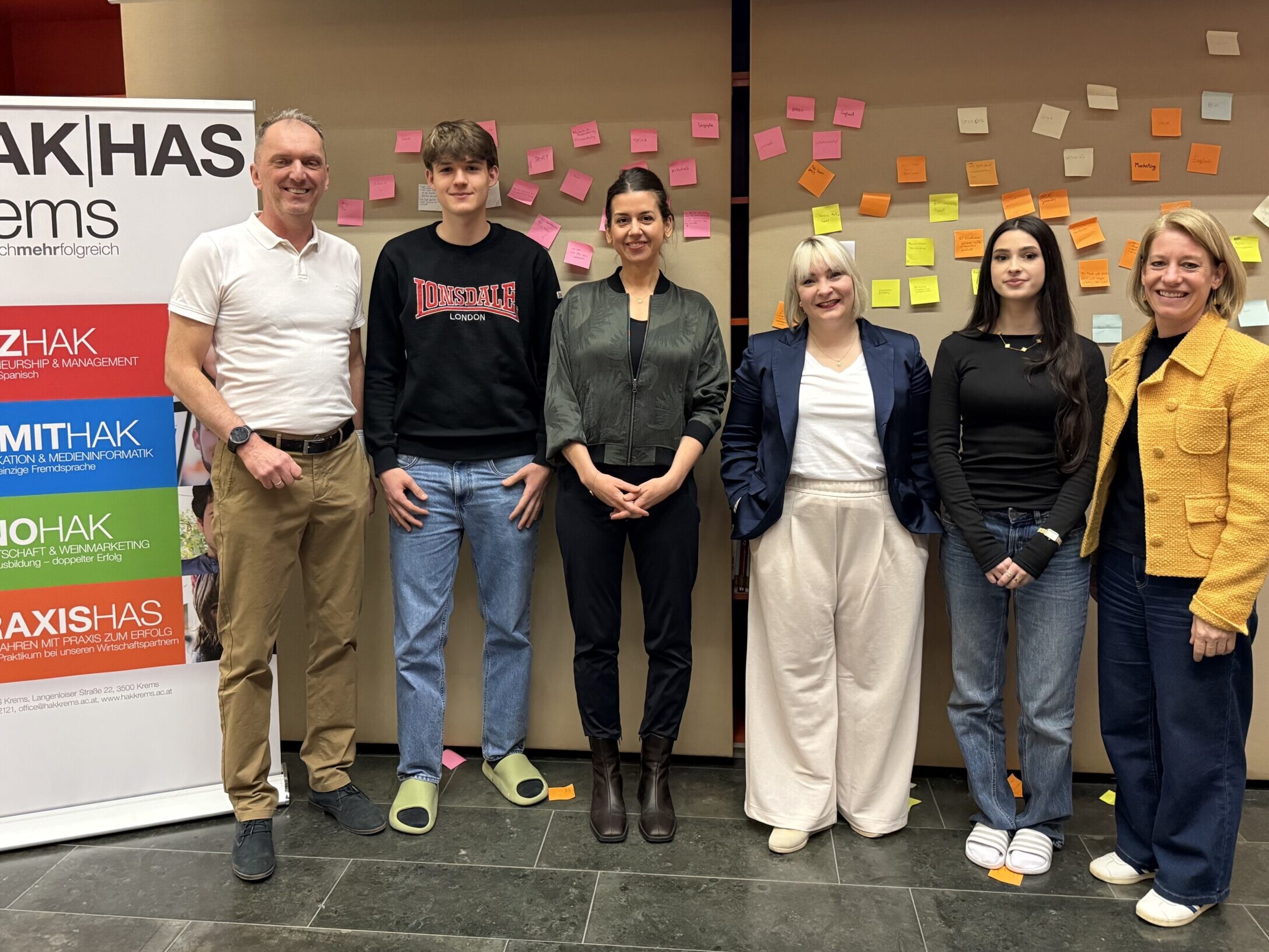 2 Lehrer:innen, 2 Schüler:innen und 2 Betreuerinnen des Entrepreneurship-Day stehen vor einer Wand mit Post-Its.