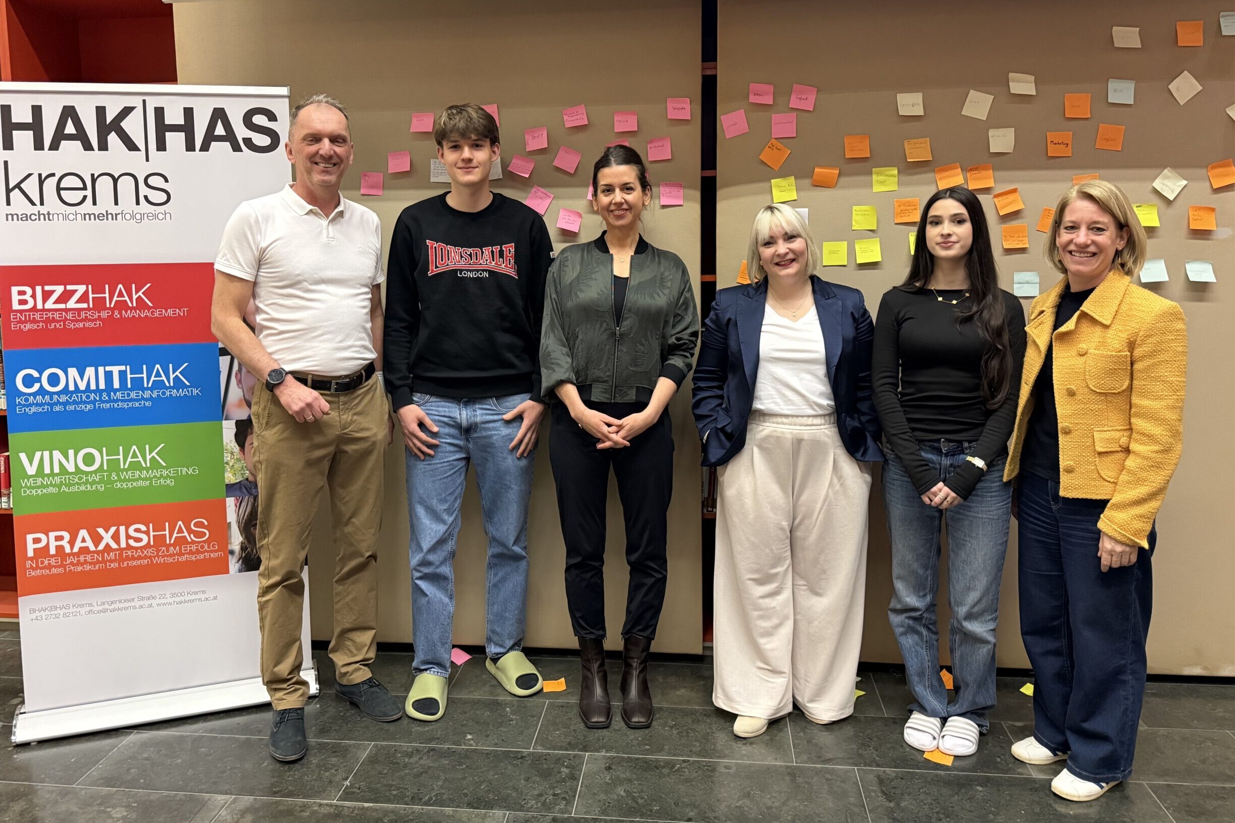 2 Lehrer:innen, 2 Schüler:innen und 2 Betreuerinnen des Entrepreneurship-Day stehen vor einer Wand mit Post-Its.