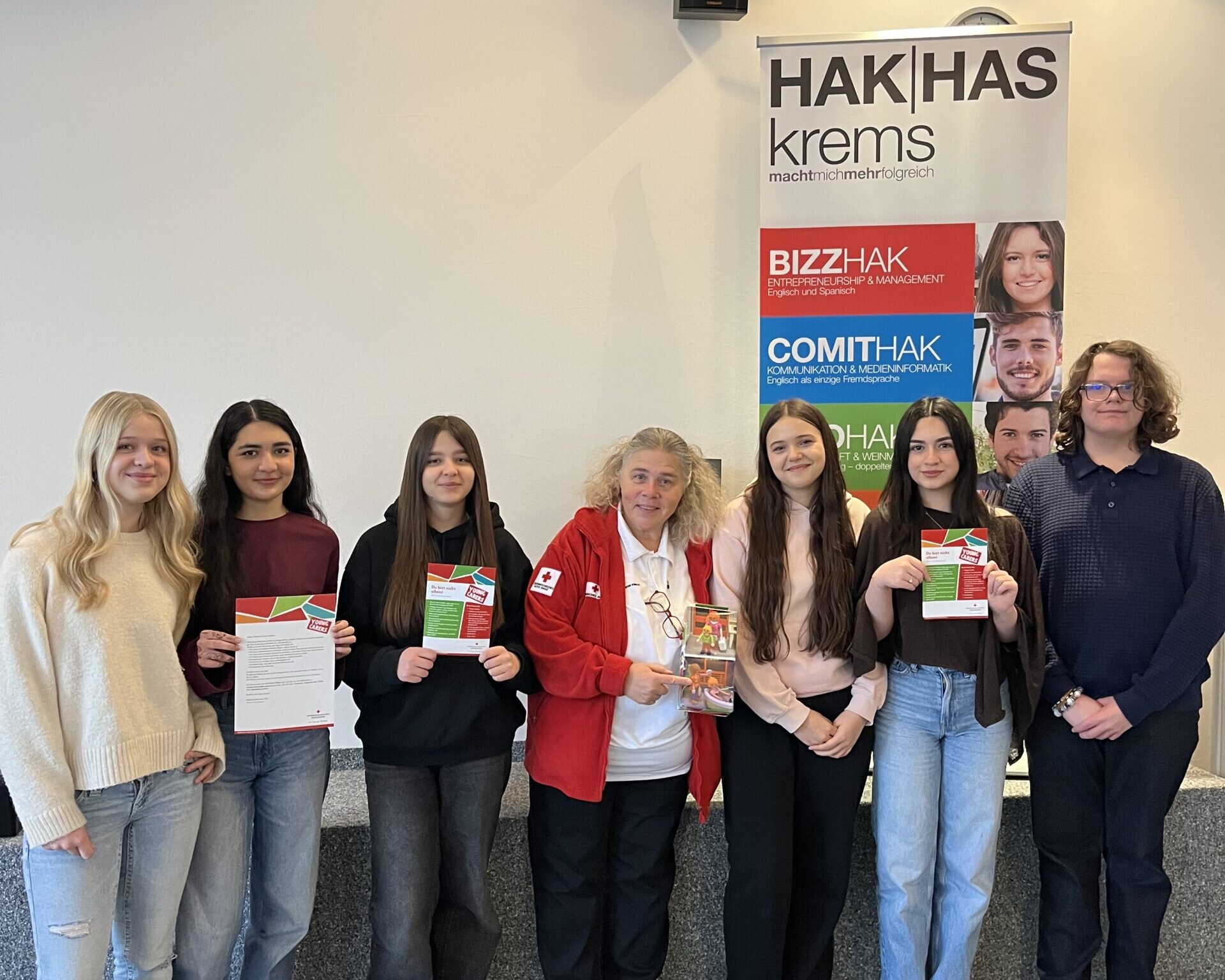 5 Schülerinnen, 1 Schüler und eine Frau vom Roten Kreuz lächeln in die Kamera.