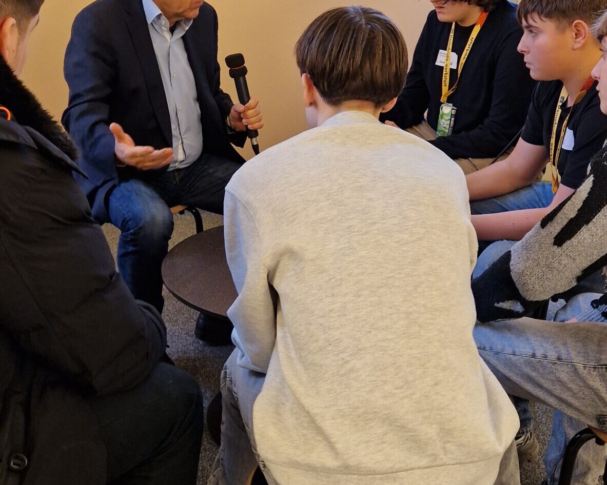 Fünf Schüler im Kreis sitzend, bei einem Interview mit ORF-Journalisten Dr. Robert Stoppacher.